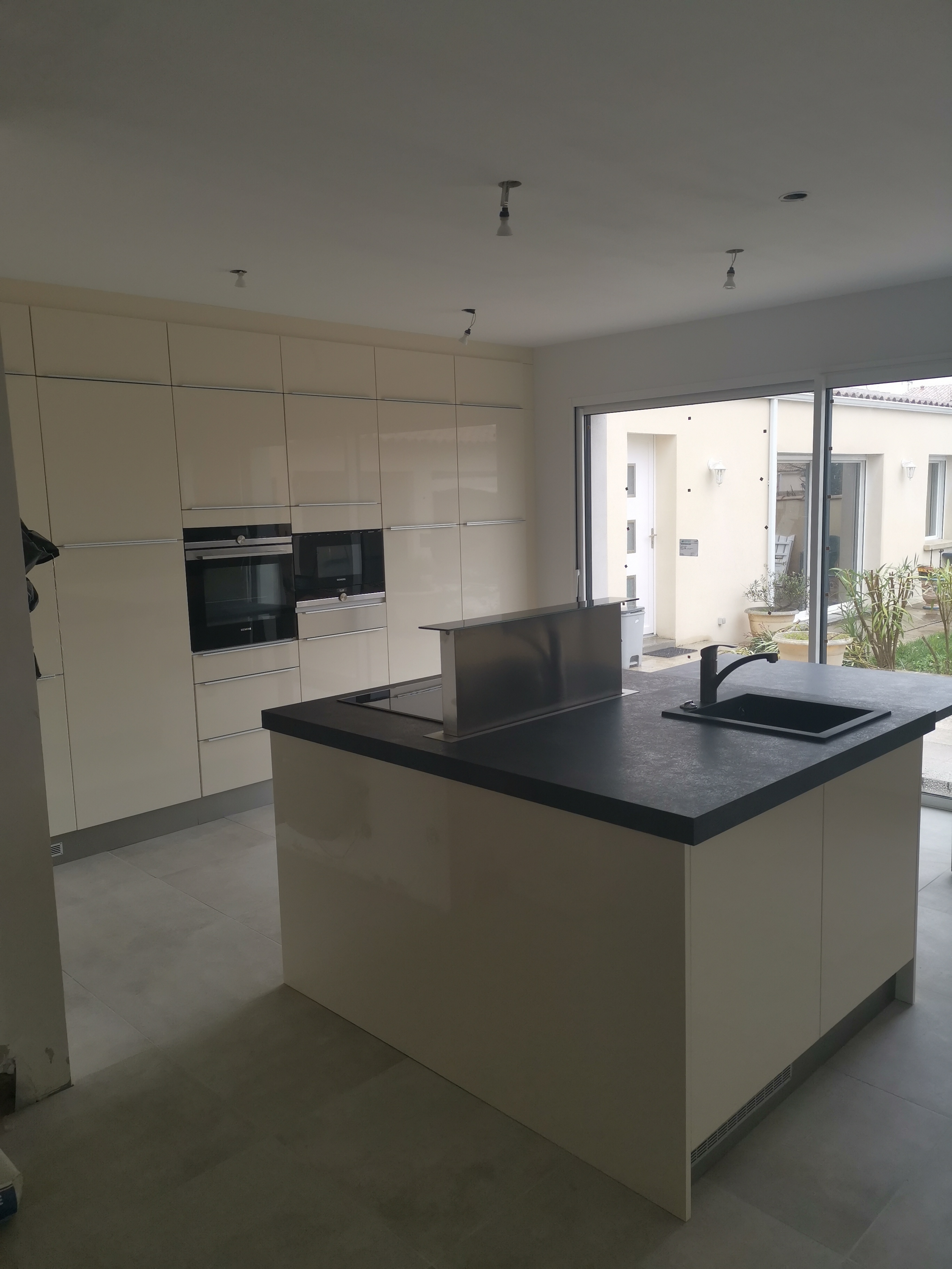 ensemble cuisine équipée avec ilot centrale et hotte dans plan de travail