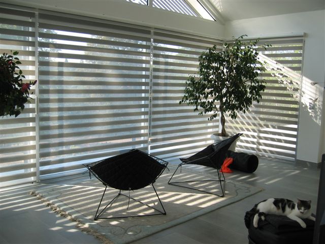 Store intérieur décoratif, permettant, grace à son double-jeu de tissu, de recouvrir partiellement ou totalement les bandes transparentes horizontales.