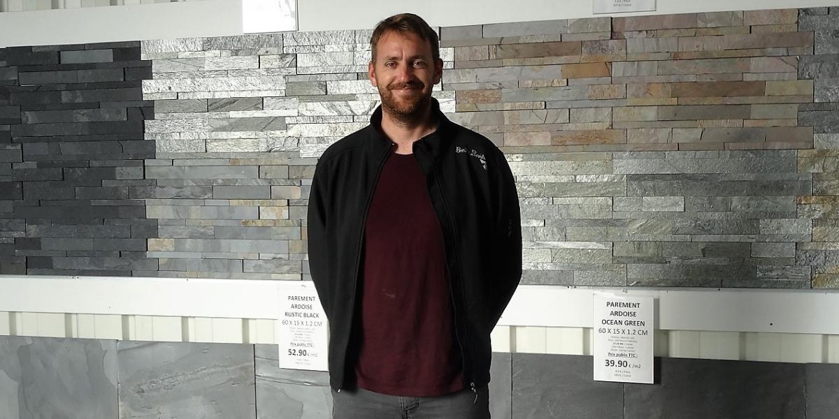 Gwendal le Badezet devant le mur du showroom de Granit Grand Ouest