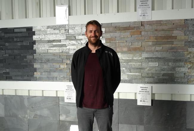 Gwendal le Badezet devant le mur du showroom de Granit Grand Ouest